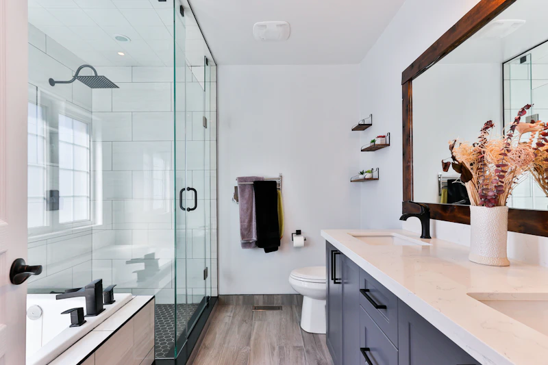 Clear glass shower enclosure alongside a freestanding bathtub